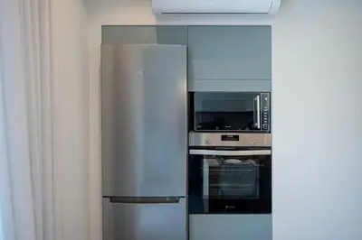 a stainless steel refrigerator with a microwave and an oven at Santa Marina Luxury Apartments #1 with pool in Asgourou
