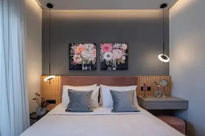 a bedroom with a bed with three flowers on the wall at Santa Marina Luxury Apartments #1 with pool in Asgourou