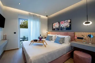 a bedroom with a large bed with a table on it at Santa Marina Luxury Apartments #1 with pool in Asgourou
