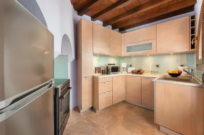 a kitchen with wooden cabinets and a refrigerator at Residenza Maria Lindos Villa in Líndos