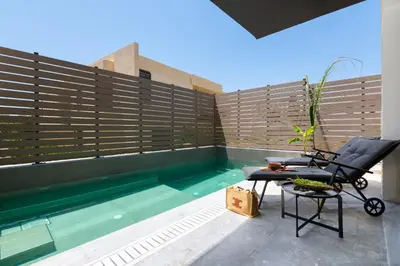 a patio with a chair and a swimming pool at La Siesta Villas in Ixia