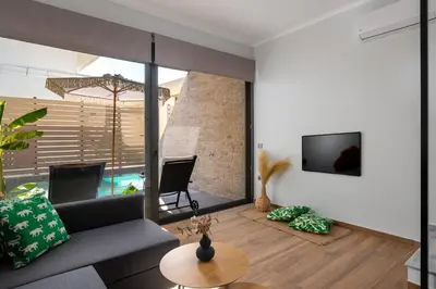 a living room with a couch and a tv on a wall at La Siesta Villas in Ixia