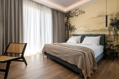 a bedroom with a large bed and a chair at La Siesta Villas in Ixia