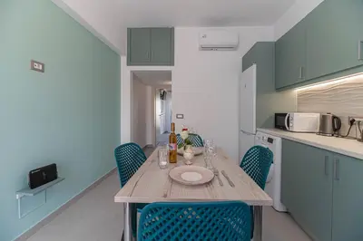 a small kitchen with a wooden table and chairs at Antonis Studio in Archangelos