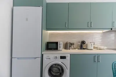 a kitchen with a washing machine and a microwave at Antonis Studio in Archangelos
