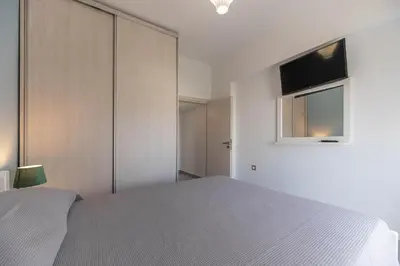 a bedroom with a bed and a tv on the wall at Antonis Studio in Archangelos