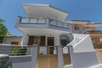 a white house with a balcony and stairs at Antonis Studio in Archangelos