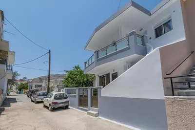 a white building with cars parked on a street at Antonis Studio in Archangelos