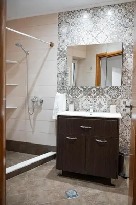a bathroom with a sink and a shower with a mirror at Marianthi's House in Émbonas