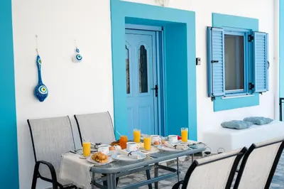 a table with plates of food on it with a blue door at Marianthi's House in Émbonas