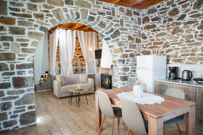 a kitchen and living room with a stone wall at Marianthi's House in Émbonas