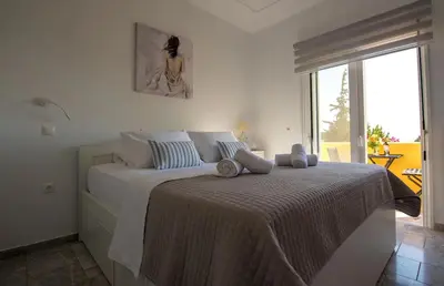 a bedroom with a large bed with a large window at Le Petit Refuge 2 Floor Maisonette with Seaview in Archangelos