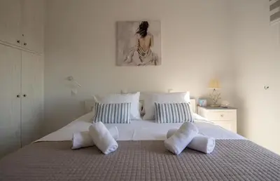 a bedroom with a large white bed with pillows at Le Petit Refuge 2 Floor Maisonette with Seaview in Archangelos