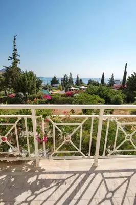 a white railing on a bridge with flowers at Le Petit Refuge 2 Floor Maisonette with Seaview in Archangelos