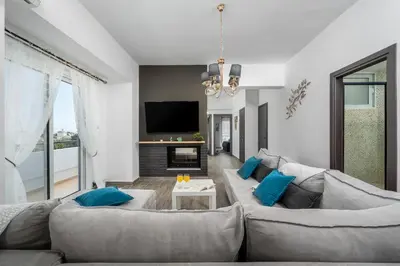 a living room with a couch and a tv at Emerald City Apartment in Rhodes Town