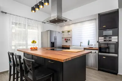 a kitchen with a large wooden island in a kitchen at Emerald City Apartment in Rhodes Town