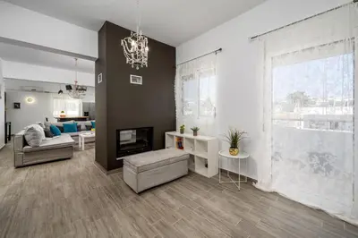 a living room with a large window and a couch at Emerald City Apartment in Rhodes Town