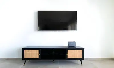 a black dresser with a flat screen tv on a wall at Mairyloy city luxury apartment in Rhodes Town