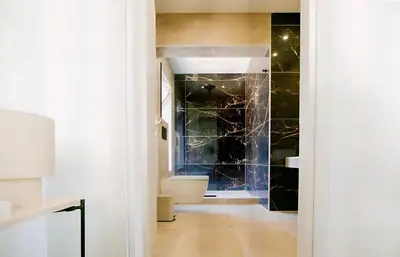 a bathroom with a toilet and a tile wall at Mairyloy city luxury apartment in Rhodes Town