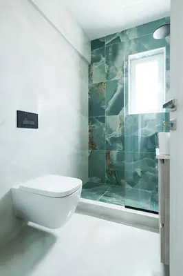 a white bathroom with a toilet and a window at Mairyloy city luxury apartment in Rhodes Town