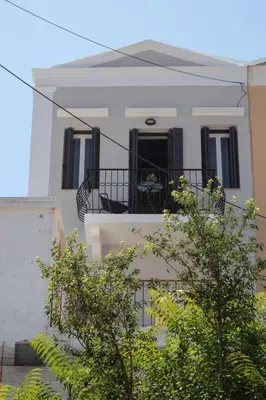 a white house with black windows and a balcony at Duchess Harbour View in Symi