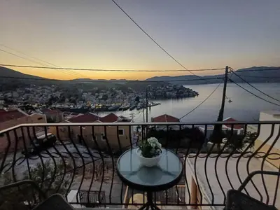 a balcony with a table and a view of the water at Duchess Harbour View in Symi