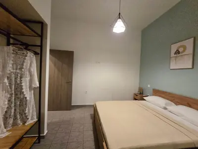 a bedroom with a bed and a closet with a dress at Filoxenia house in Kremasti