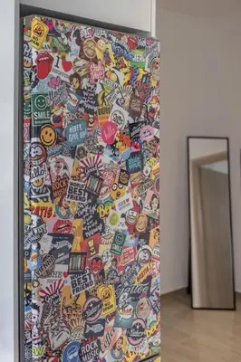 a wall covered in lots of stickers next to a doorway at Andreas Rodos Apartment in Rhodes Town