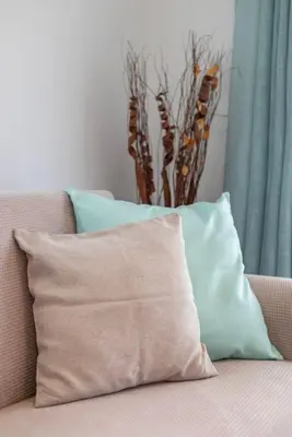 a pillow sitting on a couch with a vase at Andreas Rodos Apartment in Rhodes Town
