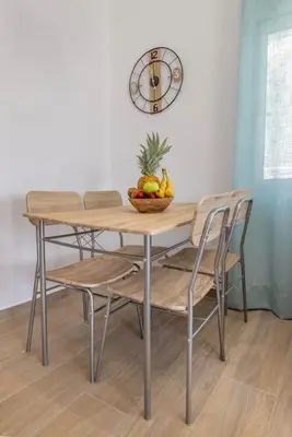 a table with chairs and a bowl of fruit on it at Andreas Rodos Apartment in Rhodes Town