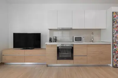 a kitchen with a stove and a tv at Andreas Rodos Apartment in Rhodes Town