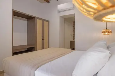 a bedroom with a white bed and a mirror at Casa di Marillia in Archangelos