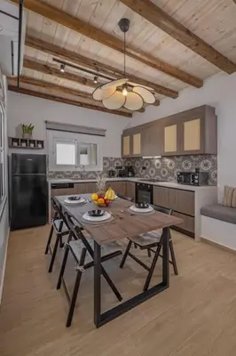 a kitchen with a table and chairs in a room at Casa di Marillia in Archangelos