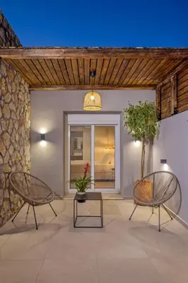 a patio with two chairs and a table and a building at Casa di Marillia in Archangelos