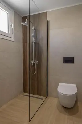 a bathroom with a toilet and a glass shower stall at Casa di Marillia in Archangelos