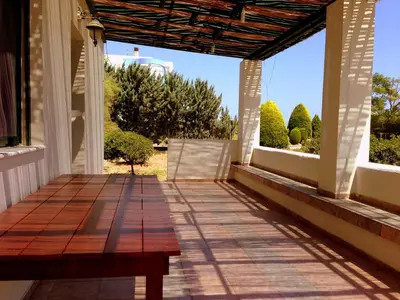 a porch with a wooden bench on a house at Seaside Villa in Gennadi