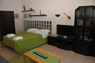 a living room with a bed and a tv at Olive Private Villa Swimming Pool 5 BDR Kolymbia Rhodes in Kolimbia