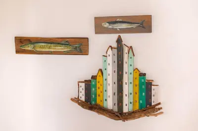 a shelf with books and fish on a wall at Kampos House in Symi