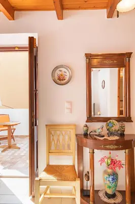 a mirror and a table and a chair in a room at Kampos House in Symi