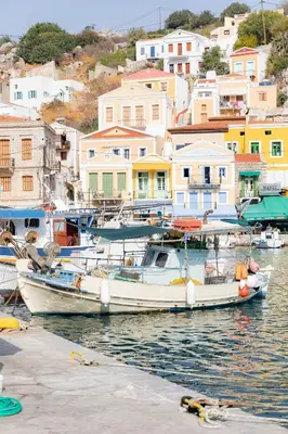 a group of boats docked in a harbor with houses at Kampos House in Symi