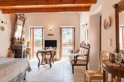 a living room with a television and a table and chairs at Kampos House in Symi