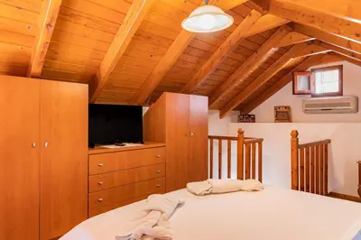 a bedroom with a bed and a flat screen tv at Kampos House in Symi