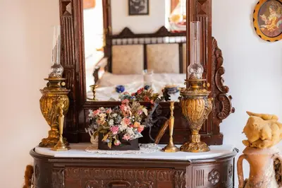 a table with a mirror and flowers on it at Kampos House in Symi