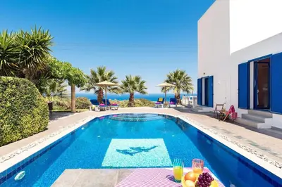 a villa with a swimming pool with a table with fruit on it at Villa Elysium in Kalathos