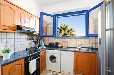 a kitchen with a washing machine and a window at Villa Elysium in Kalathos