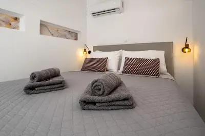 a bedroom with a bed with towels on it at Annikas Port View-1st Floor in Symi
