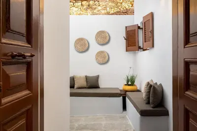 a hallway with a bench and plates on the wall at Annikas Port View-1st Floor in Symi