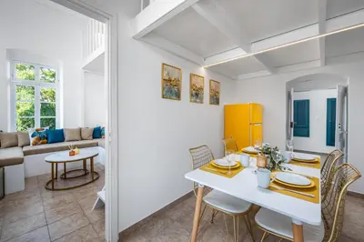 a dining room and living room with a table and chairs at Annikas Port View-1st Floor in Symi