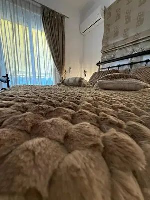 a bedroom with a large bed with furry pillows at Katsaras House 3 Cozy Bedrooms in Kremasti