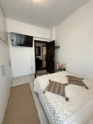a bedroom with a bed and a tv on the wall at Katsaras House 3 Cozy Bedrooms in Kremasti